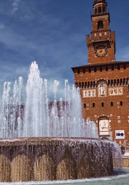 The Filarete Tower of the Castello Sforzesco behind the fountain on Piazza Castello
