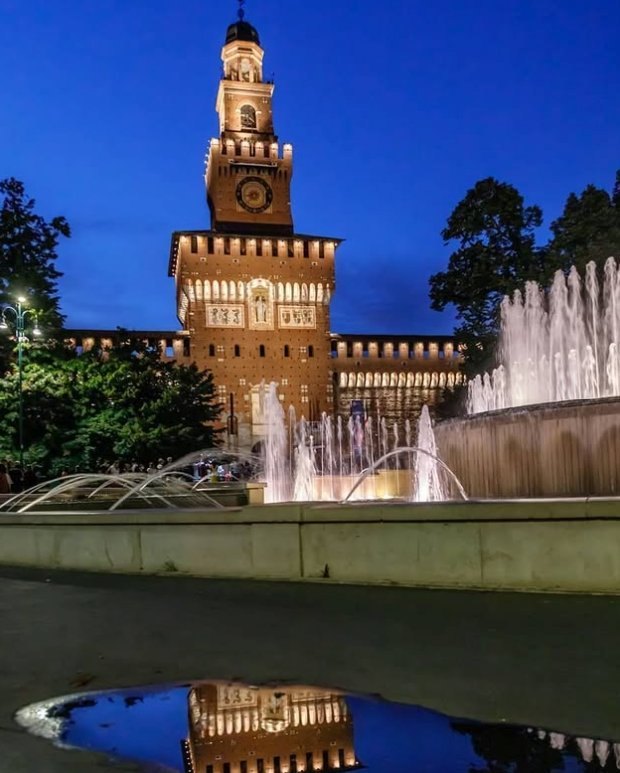 The Filarete Tower at dusk, the fountain in Piazza Castello lit below it