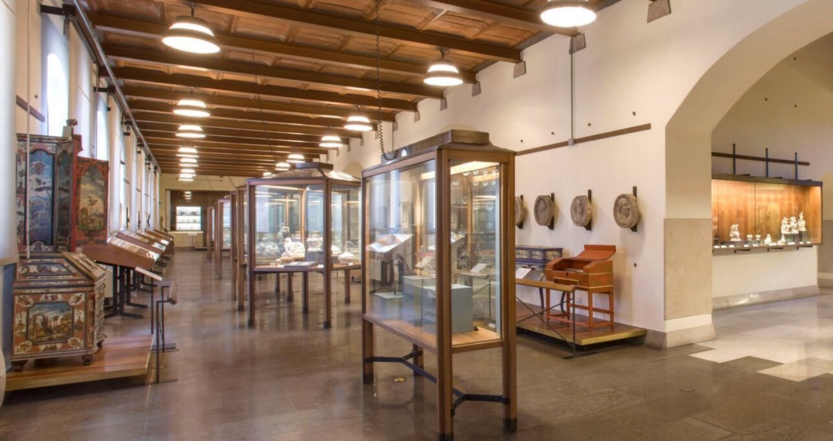 A gallery inside the Castello Sforzesco museums, sculpture set out under a vaulted ceiling