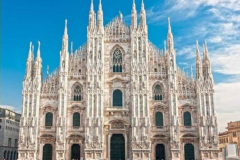 The marble west front of the Duomo against a blue sky